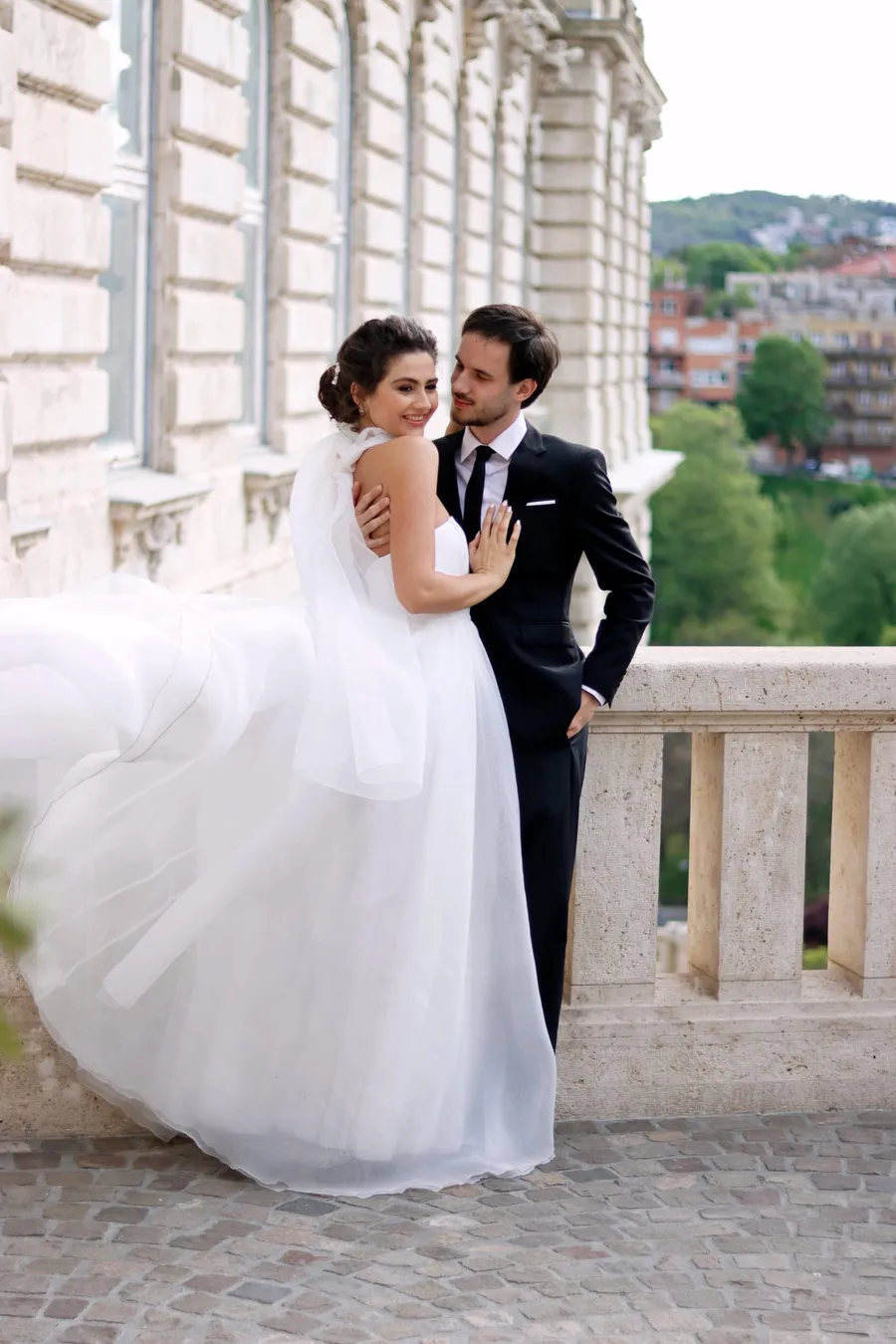 Esküvői pár átöleli egymást egy budapesti múzeum oszlopcsarnoka előtt — Gáspár Enikő Photography