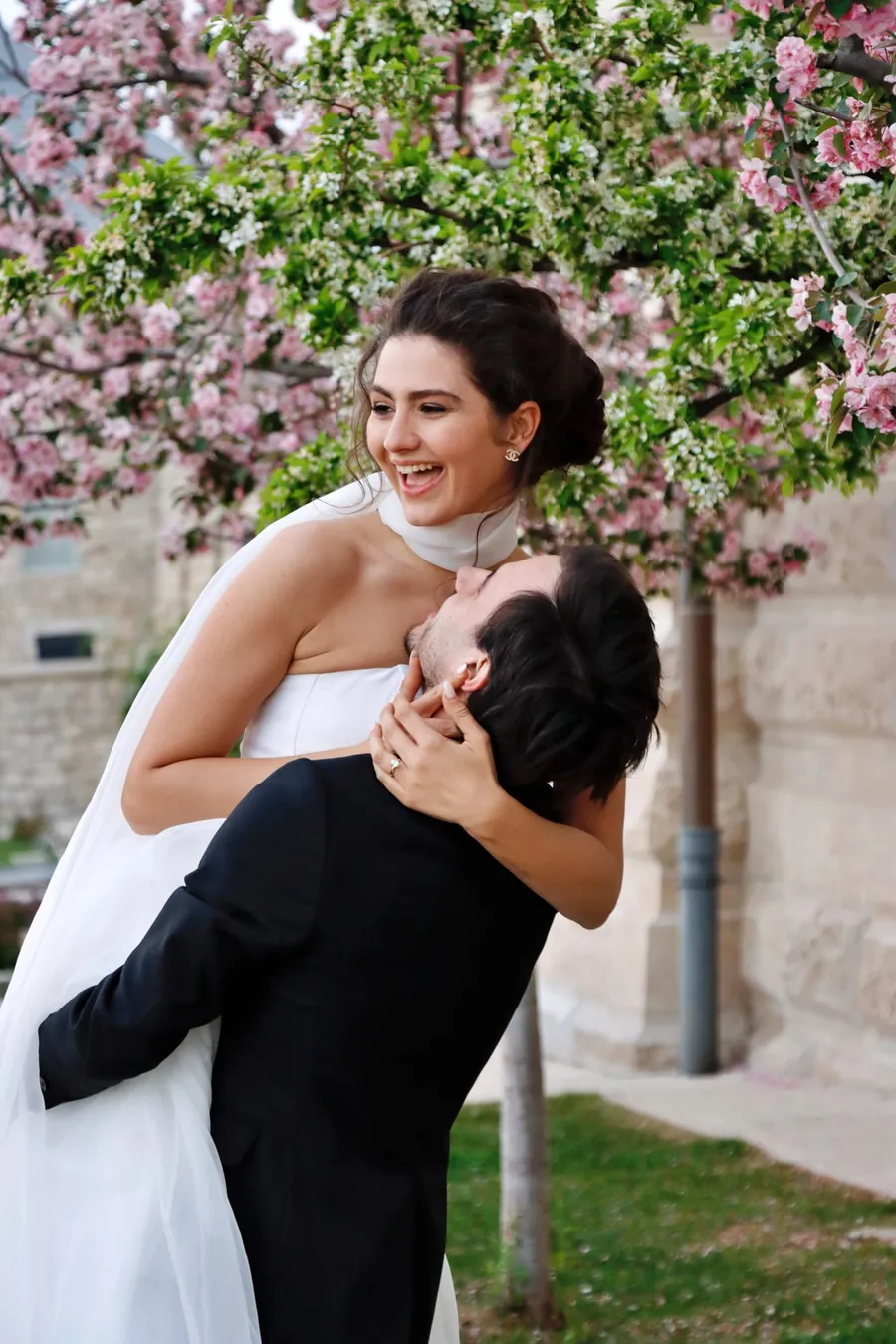 Vőlegény nevető menyasszonyt emel cseresznyevirágzás alatt, Budapest — Gáspár Enikő Photography