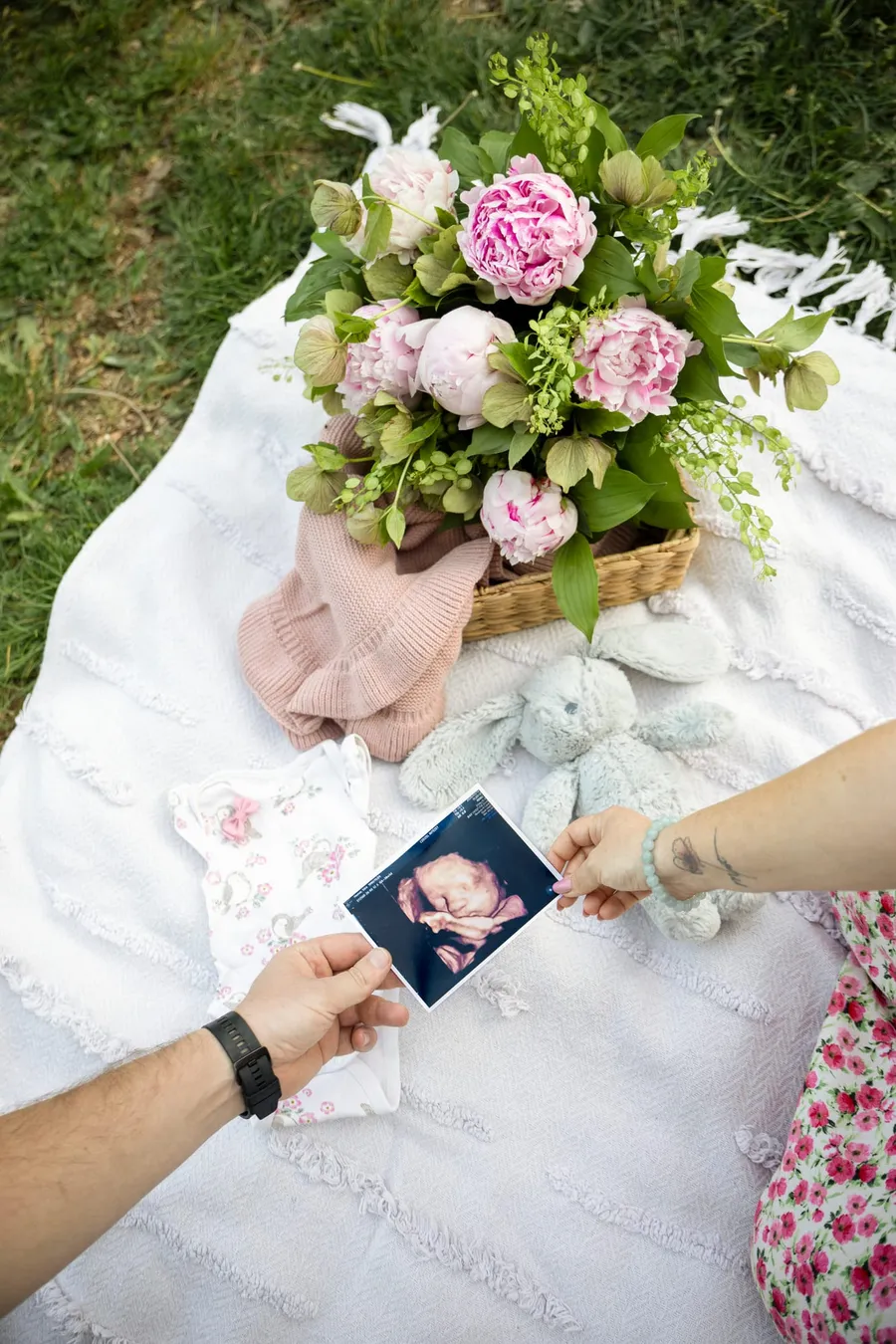Terhes fotózás flatlay felülről: ultrahangkép, virágok és babaholmik takarón — Gáspár Enikő Photography