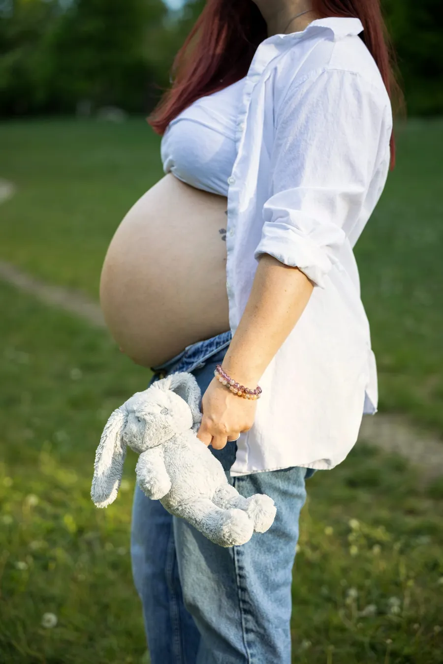 Várandós anya plüss nyuszit tart, babapocka látszik a parkban — Gáspár Enikő Photography